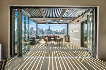a terrace with a table and chairs and a view of the city at Inspire West Town, CHICAGO, IL, 60642